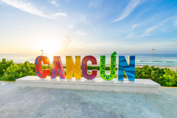 The Cancun sign at sunrise at Playa Delfines a popular beach in Cancun, Mexico